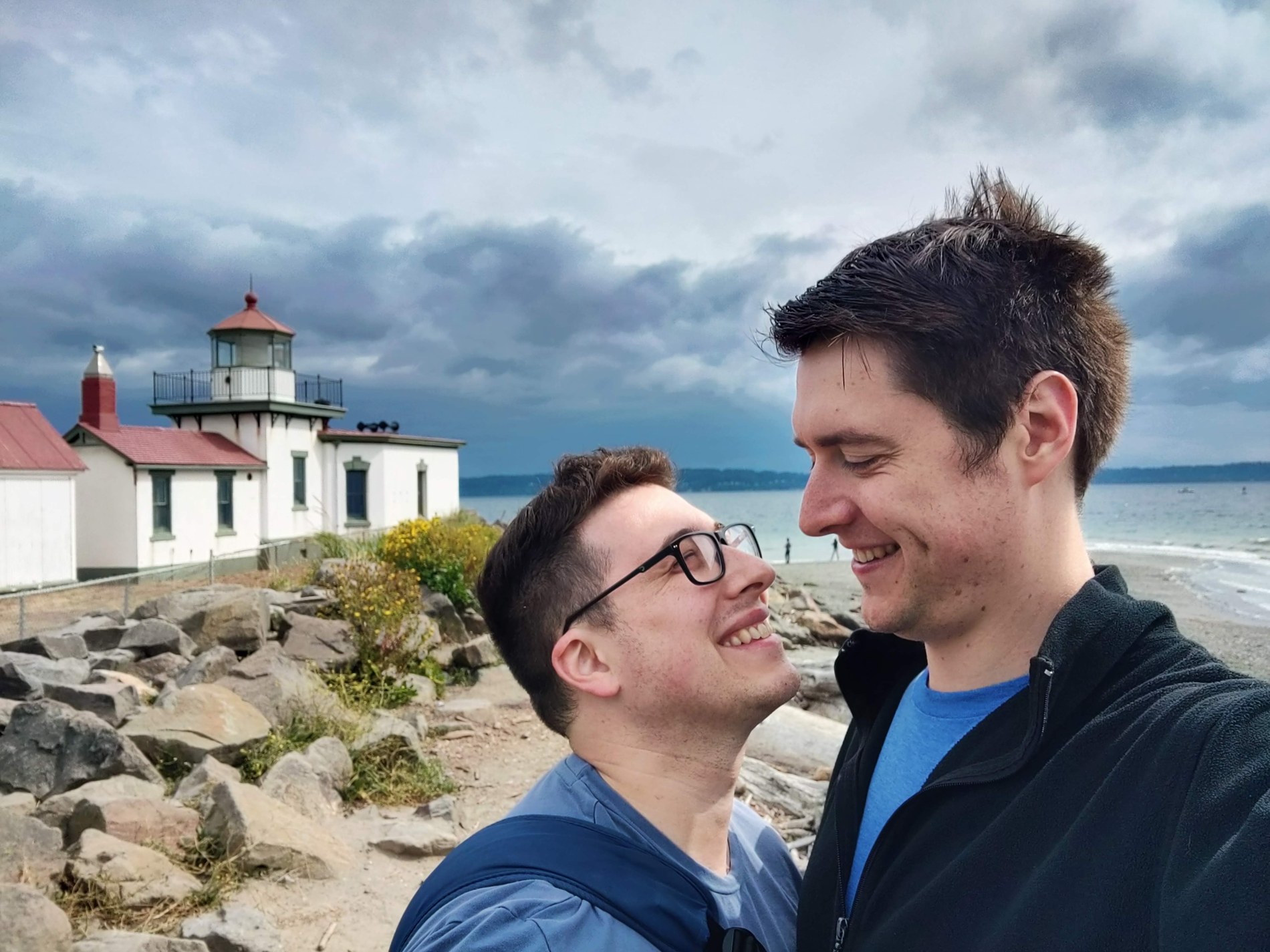 Aaron and Peter together near a lighthouse and rocky shoreline