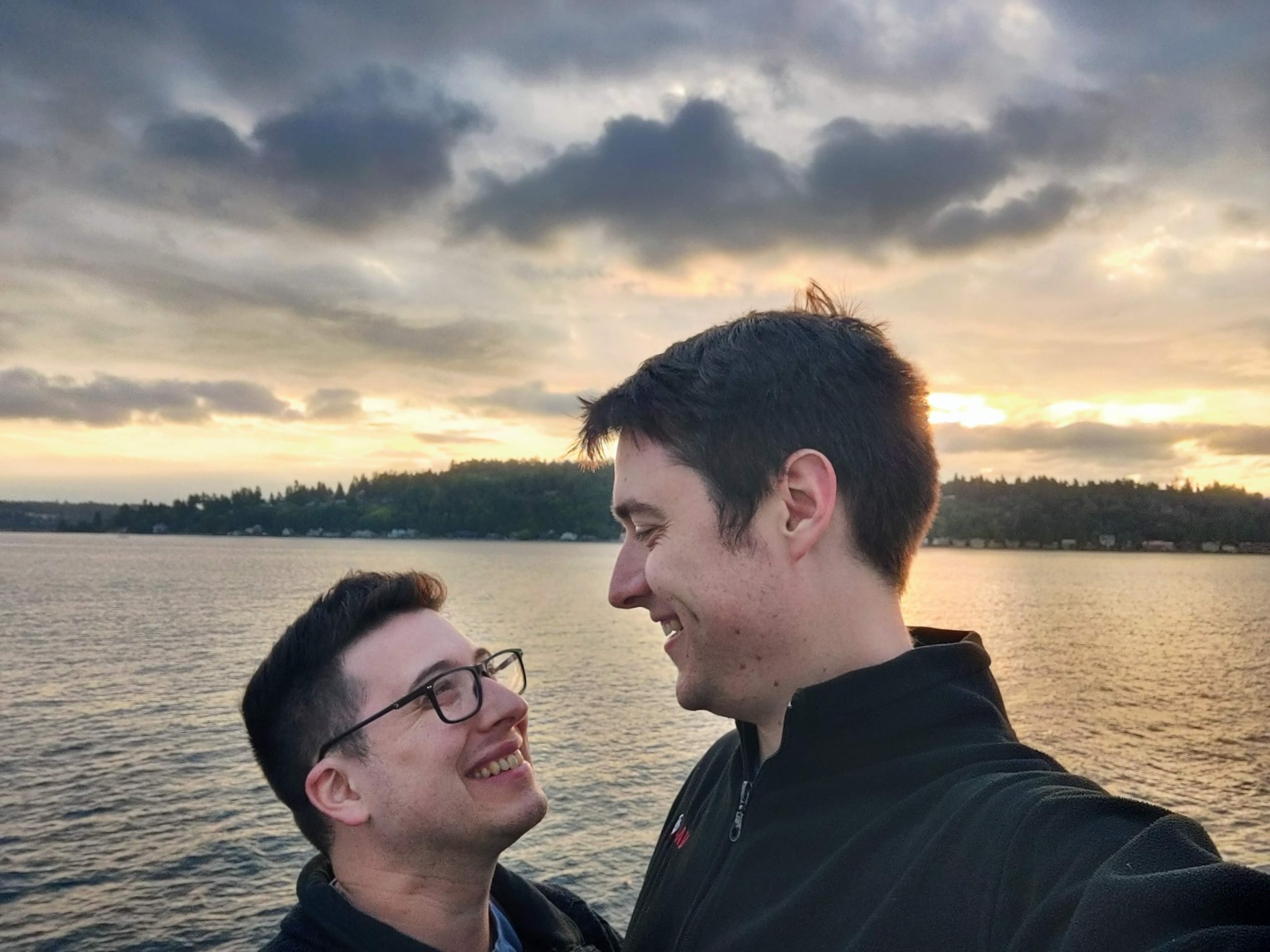 Aaron and Peter together beside the water at sunset